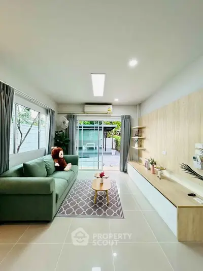 Modern living room with green sofa and sliding glass doors to patio