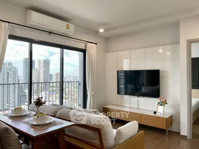 Modern living room with city view, stylish furniture, and large TV in a high-rise apartment.