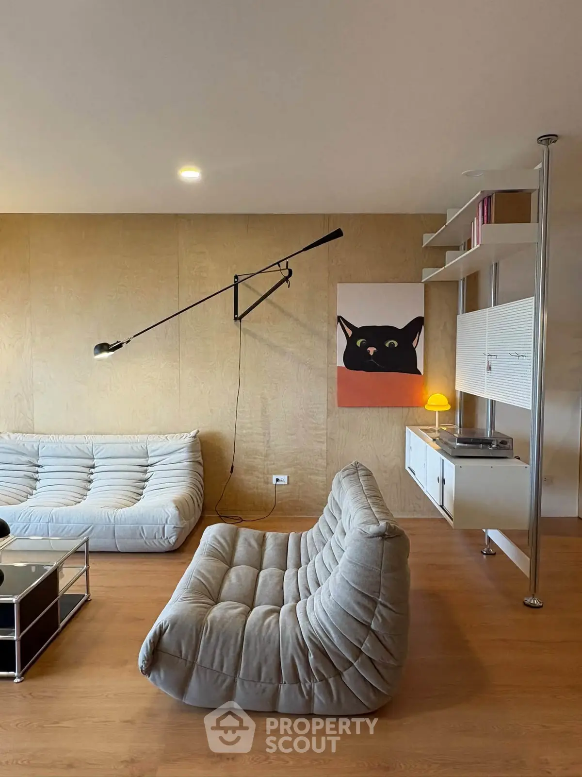Stylish modern living room with unique wall art and cozy seating, perfect for relaxation and entertaining.