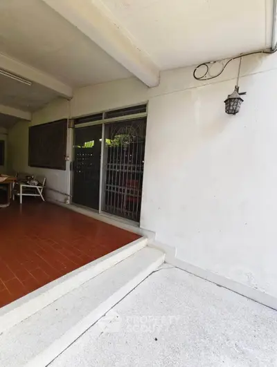 Spacious covered patio with tiled flooring and outdoor seating, perfect for relaxation.