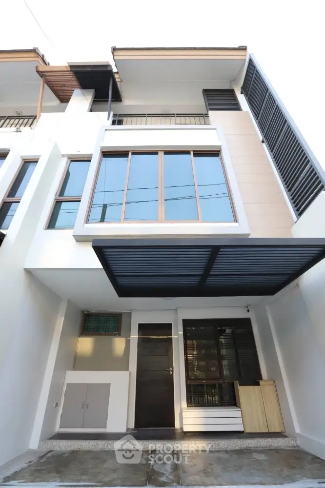 Modern townhouse exterior with large windows and covered entrance