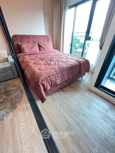 Cozy bedroom with large windows and stylish decor, perfect for relaxation and comfort.