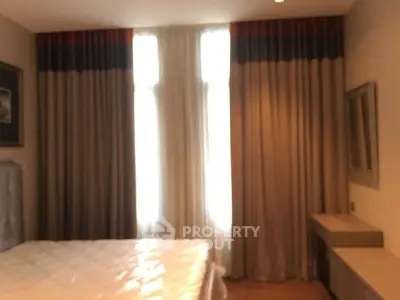 Cozy bedroom with elegant curtains and a comfortable bed, perfect for relaxation.