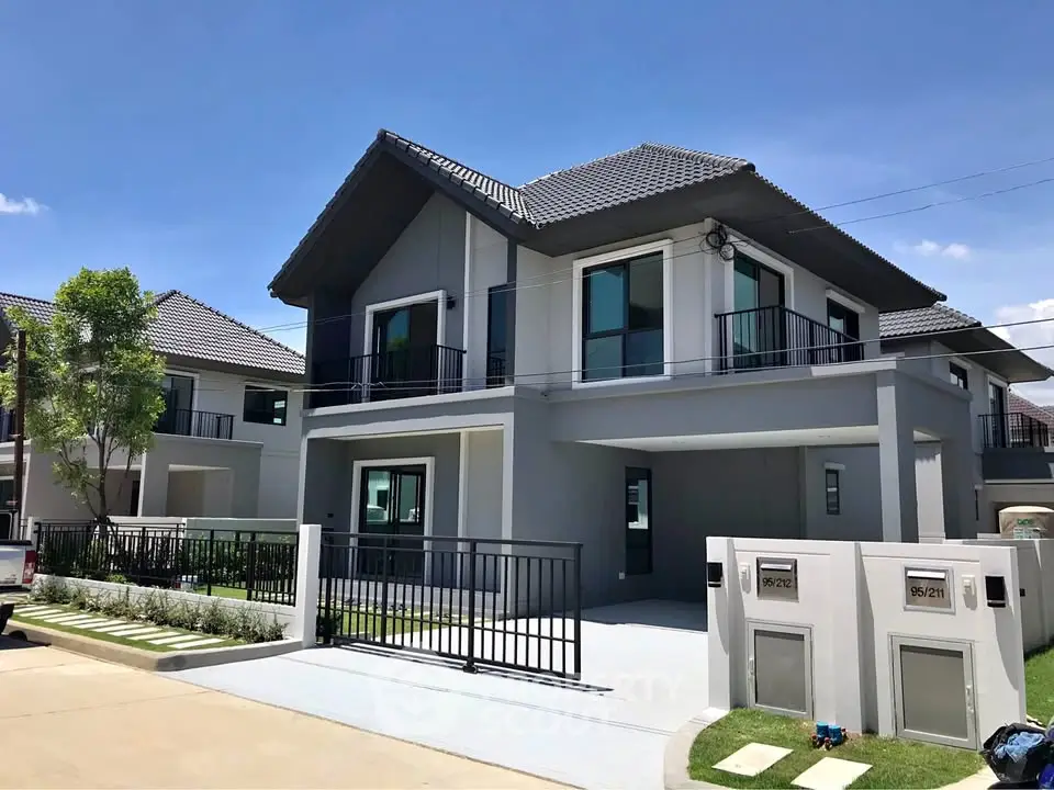 Modern two-story house with sleek design and spacious driveway in a suburban neighborhood.