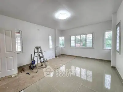 Spacious unfurnished room with tiled floor and large windows, ideal for customization.