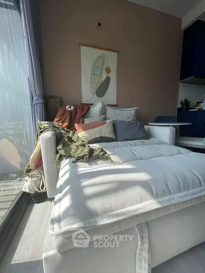 Cozy living room with stylish decor and natural light, featuring a comfortable sofa and modern wall art.