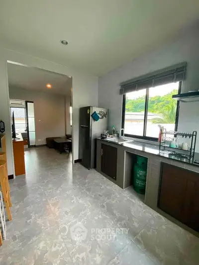 Spacious kitchen with modern appliances and open layout, featuring large windows and scenic views.