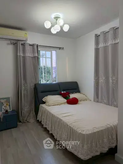 Cozy bedroom with elegant curtains and modern lighting, perfect for relaxation.