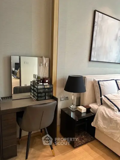 Modern bedroom with stylish decor and elegant furniture, featuring a cozy bed and a sleek vanity desk.