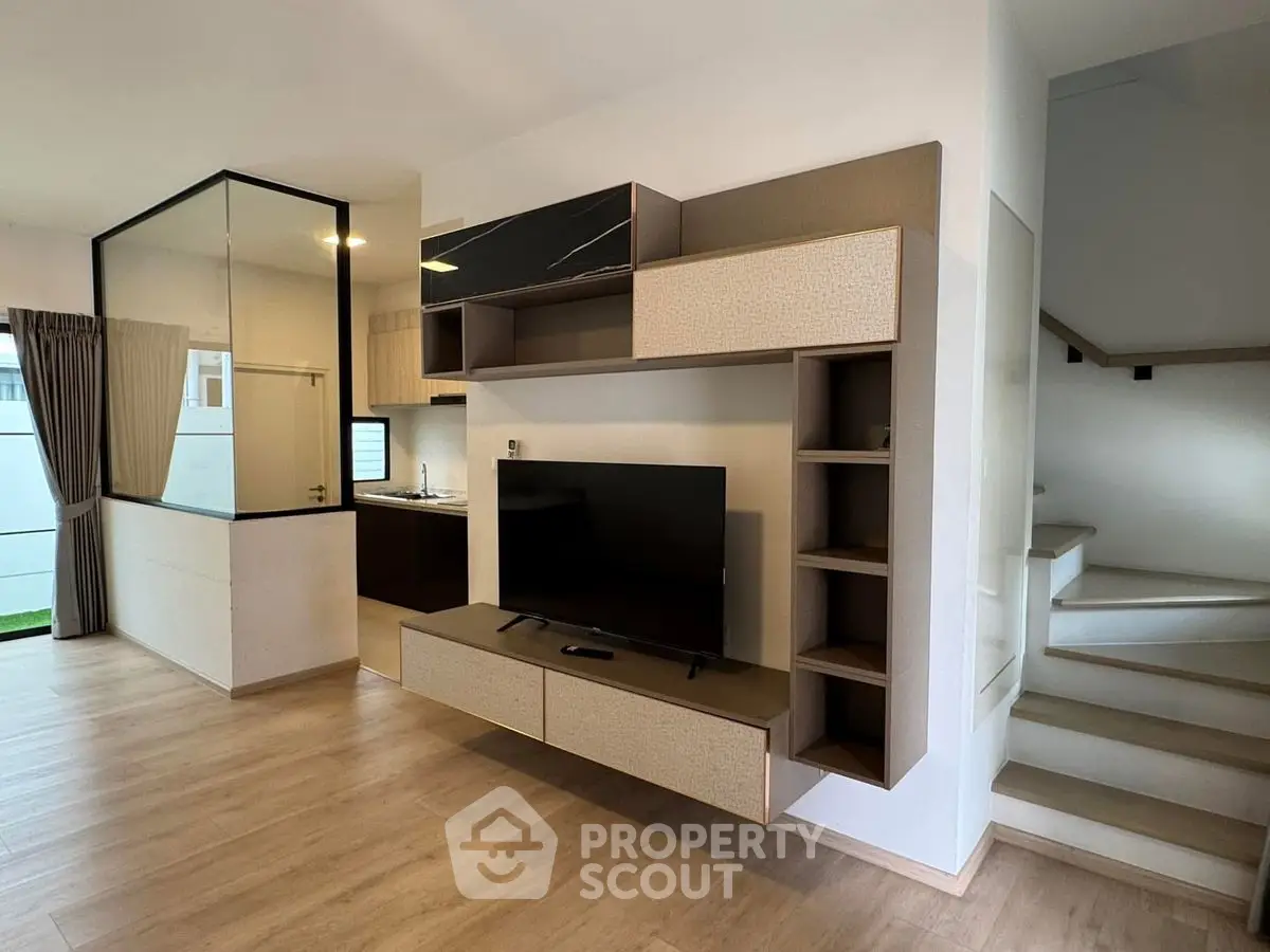 Modern living room with stylish TV unit and open kitchen layout