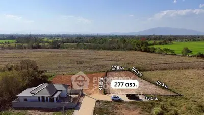 Expansive land plot with countryside views and a small house, ideal for development.