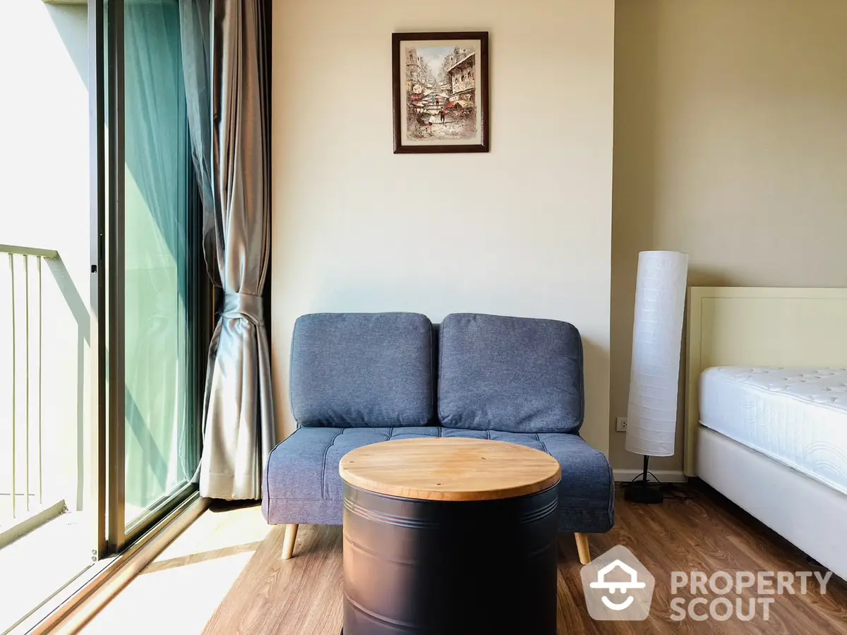 Cozy studio apartment with modern furnishings, ample natural light, and a charming balcony offering a serene outdoor space.