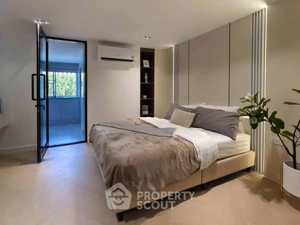Modern bedroom with cozy decor and natural light, featuring a comfortable bed and stylish furnishings.