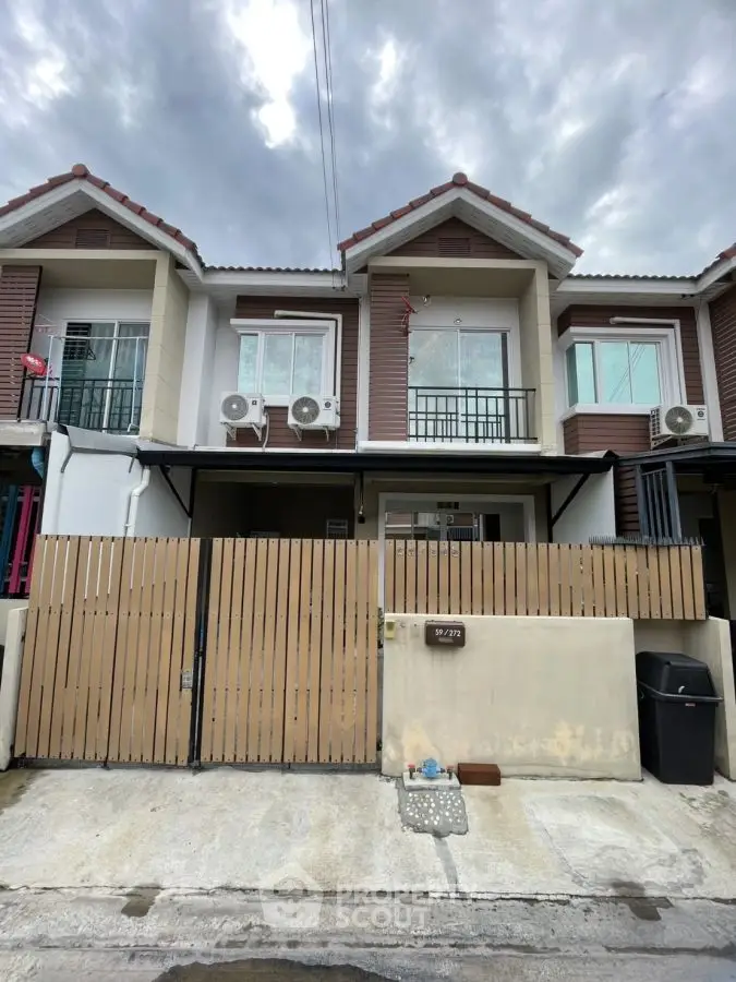 Charming townhouse with modern facade and gated entrance in a serene neighborhood.