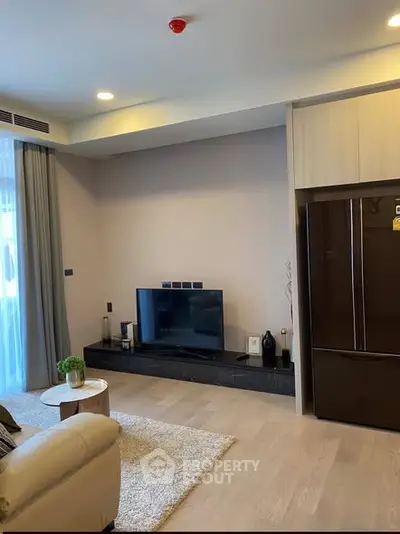 Modern living room with sleek TV setup and cozy seating area.