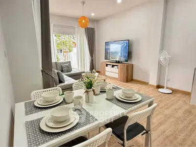 Modern living room with dining area, stylish decor, and natural light in a cozy apartment.