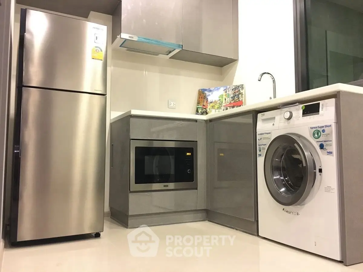 Modern kitchen with stainless steel appliances and washing machine