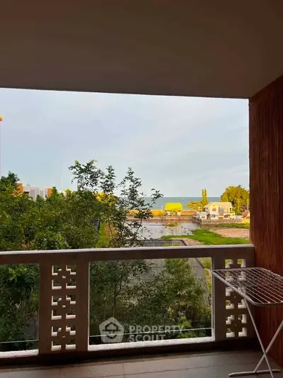 Stunning balcony view overlooking lush greenery and serene water, perfect for relaxation.