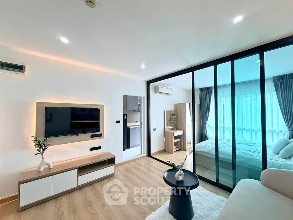Modern living room with glass partition and cozy bedroom in stylish apartment