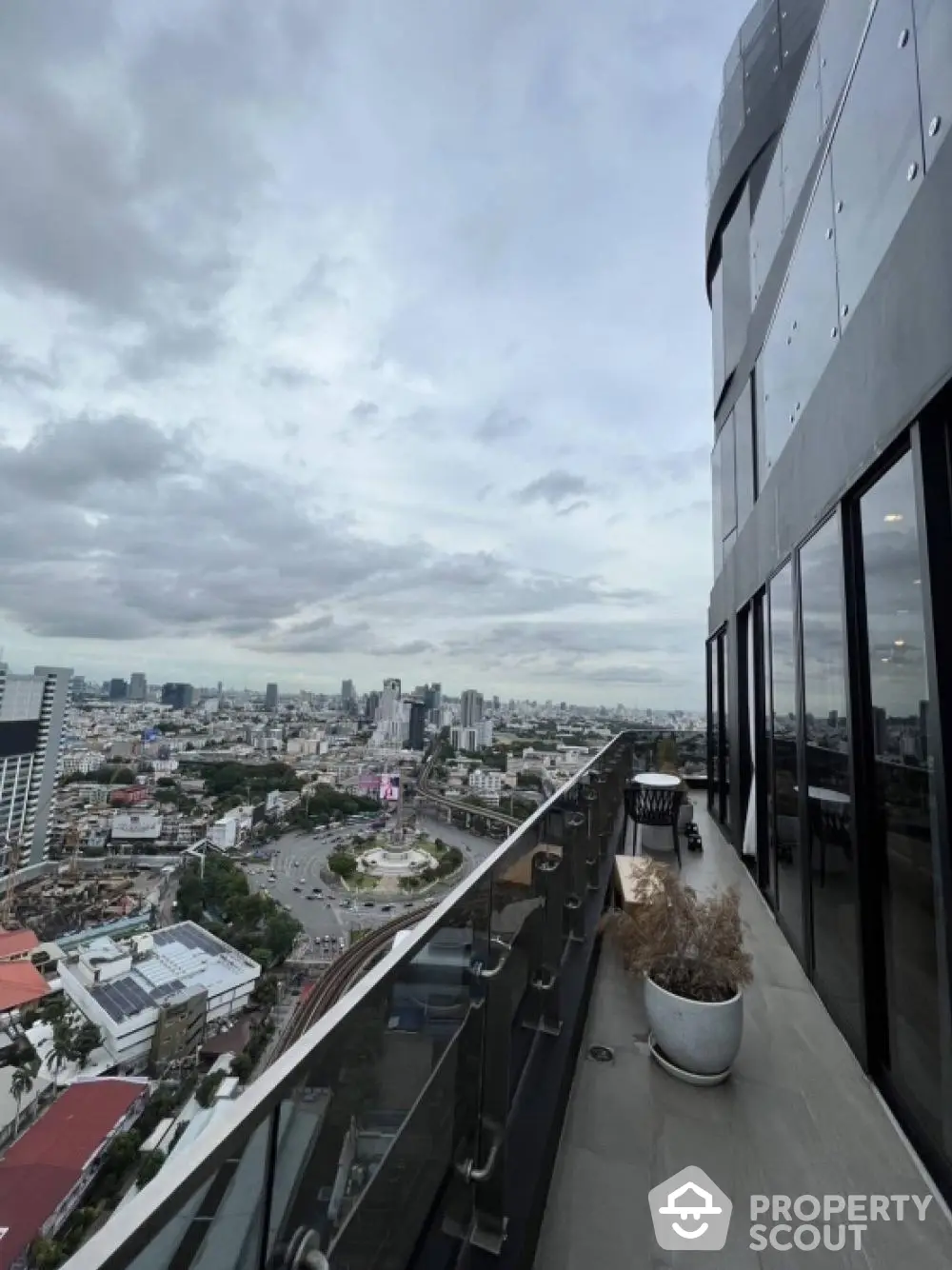 Stunning cityscape view from modern high-rise balcony with glass railing.