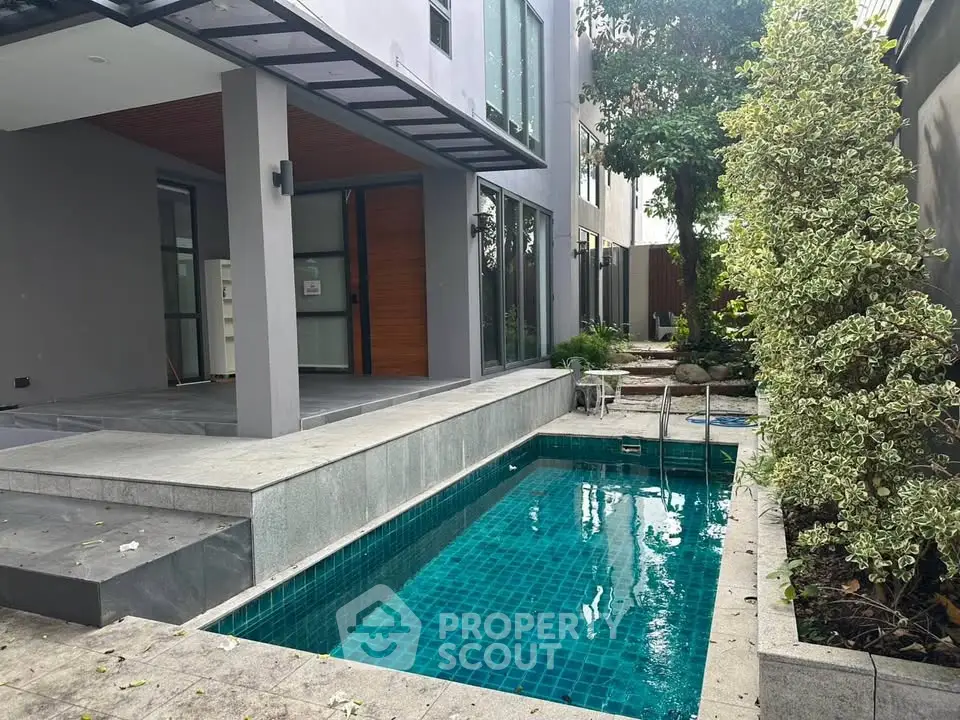 Modern home exterior with sleek pool and lush greenery, perfect for luxury living.