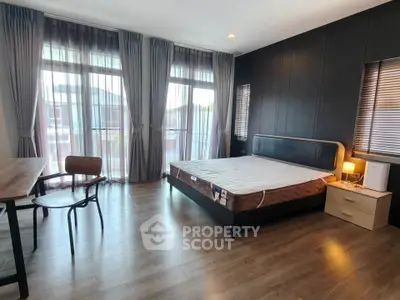Spacious bedroom with large windows and modern decor, perfect for relaxation and comfort.