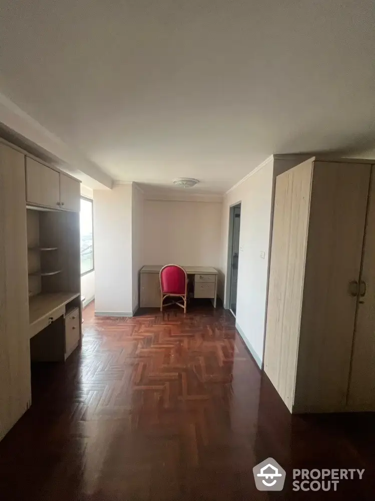 Spacious study room with elegant wooden flooring and built-in storage