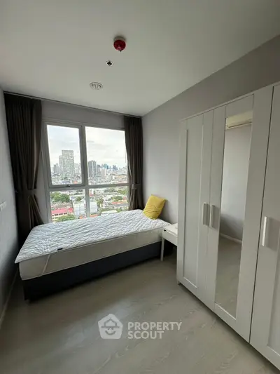 Modern bedroom with city view, featuring a cozy bed and sleek wardrobe.