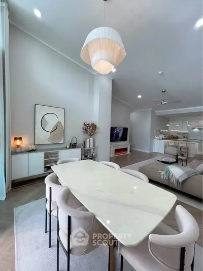 Elegant open-plan living and dining area with modern decor and stylish lighting.