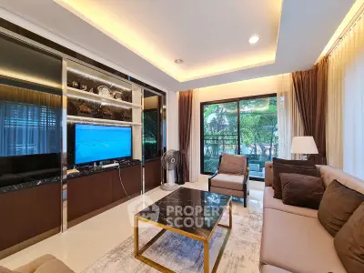 Luxurious living room with modern decor and large windows overlooking greenery.