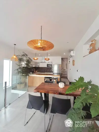 Modern open-plan kitchen and dining area with stylish lighting and wooden accents