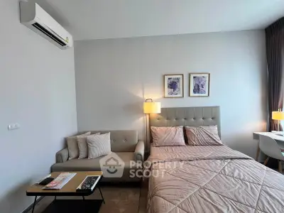Modern bedroom with cozy sofa and stylish decor in a contemporary apartment.