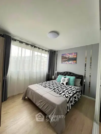 Modern bedroom with stylish decor and large window for natural light