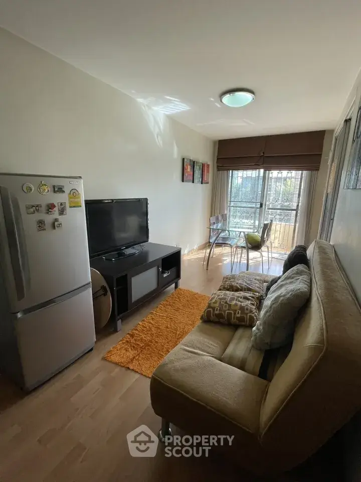 Cozy living room with natural light, modern decor, and a compact dining area.