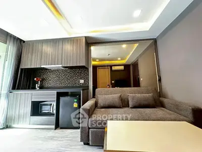 Modern living room with sleek kitchenette and cozy sofa in stylish apartment.