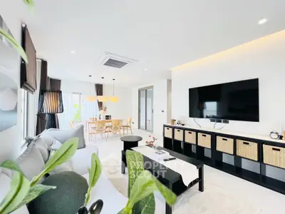Spacious modern living room with elegant decor and large TV, perfect for family gatherings.