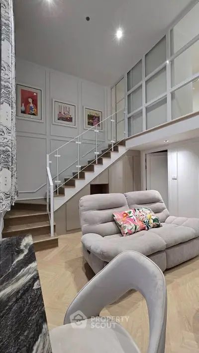 Modern duplex living room with stylish staircase and cozy seating area