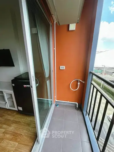 Charming balcony with sliding glass door and city view, perfect for relaxation and fresh air.