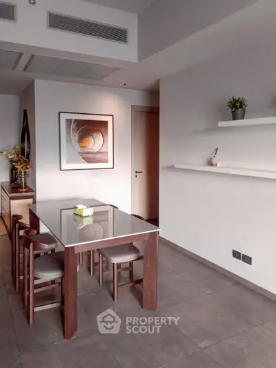 Modern dining area with sleek table and chairs, minimalist decor, and contemporary artwork.