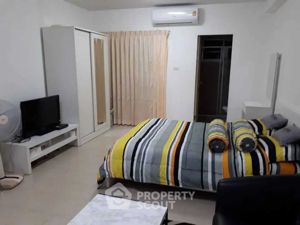 Spacious bedroom with modern decor and air conditioning in a stylish apartment.