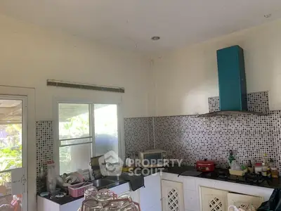 Charming kitchen with mosaic backsplash and modern appliances, perfect for culinary enthusiasts.