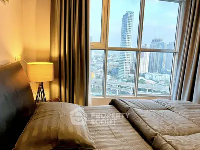 Luxurious bedroom with stunning city view from large window, featuring elegant decor and cozy ambiance.