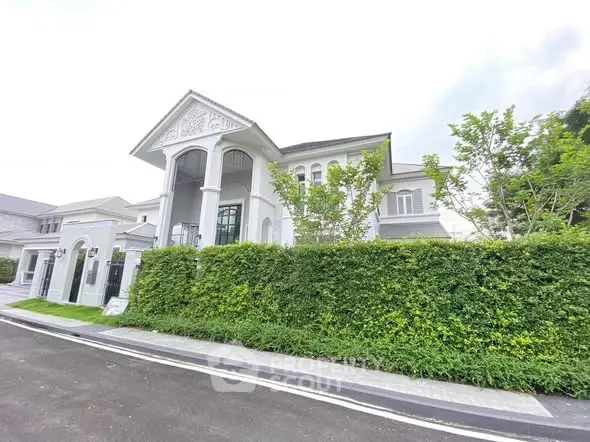Luxurious modern house with elegant architecture and lush greenery in an upscale neighborhood.