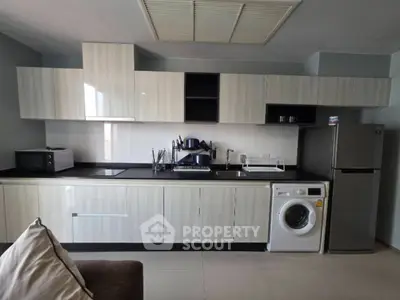 Modern kitchen with sleek cabinetry, stainless steel appliances, and integrated washing machine.