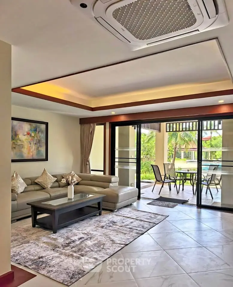 Spacious living room with modern decor and garden view, perfect for relaxation and entertaining.