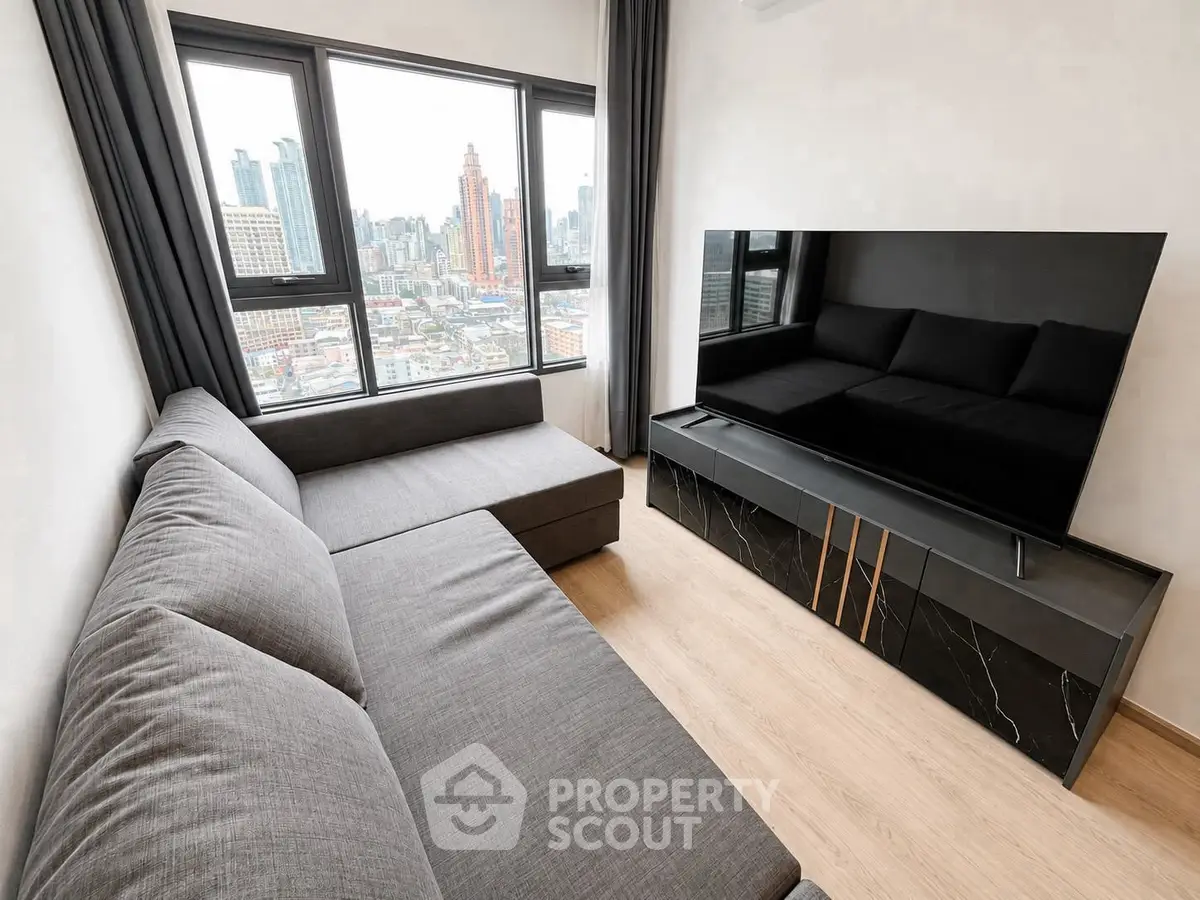 Modern living room with city view, featuring sleek furniture and large windows.