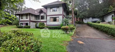 Charming two-story house with lush garden and driveway in serene setting