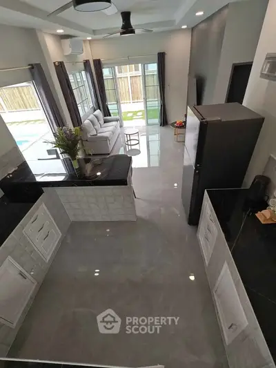 Modern open-layout kitchen and living room with sleek design and ample natural light.