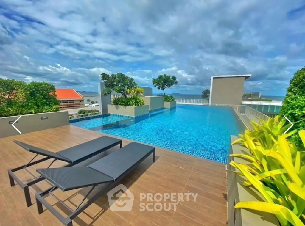 Stunning rooftop pool with panoramic ocean views and modern lounge chairs.