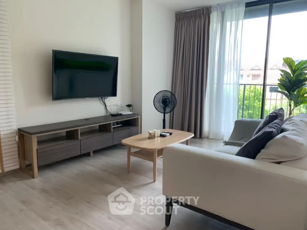 Modern living room with sleek furniture and large window offering natural light